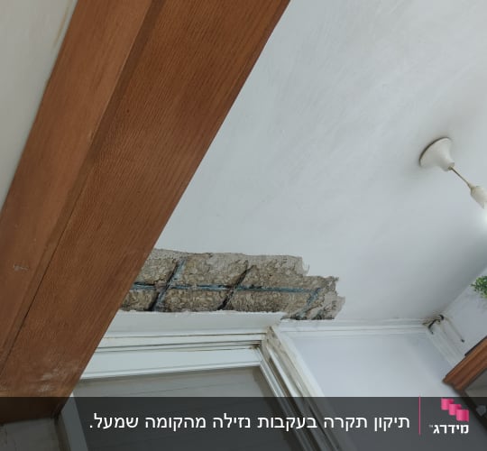 נזק לטיח ולבטון בתקרה מעל חלון לפני עבודת תיקון וצבע